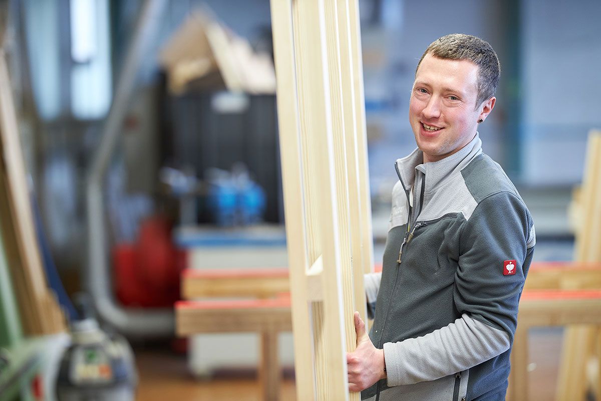 Mitarbeiter trägt Holzfenster